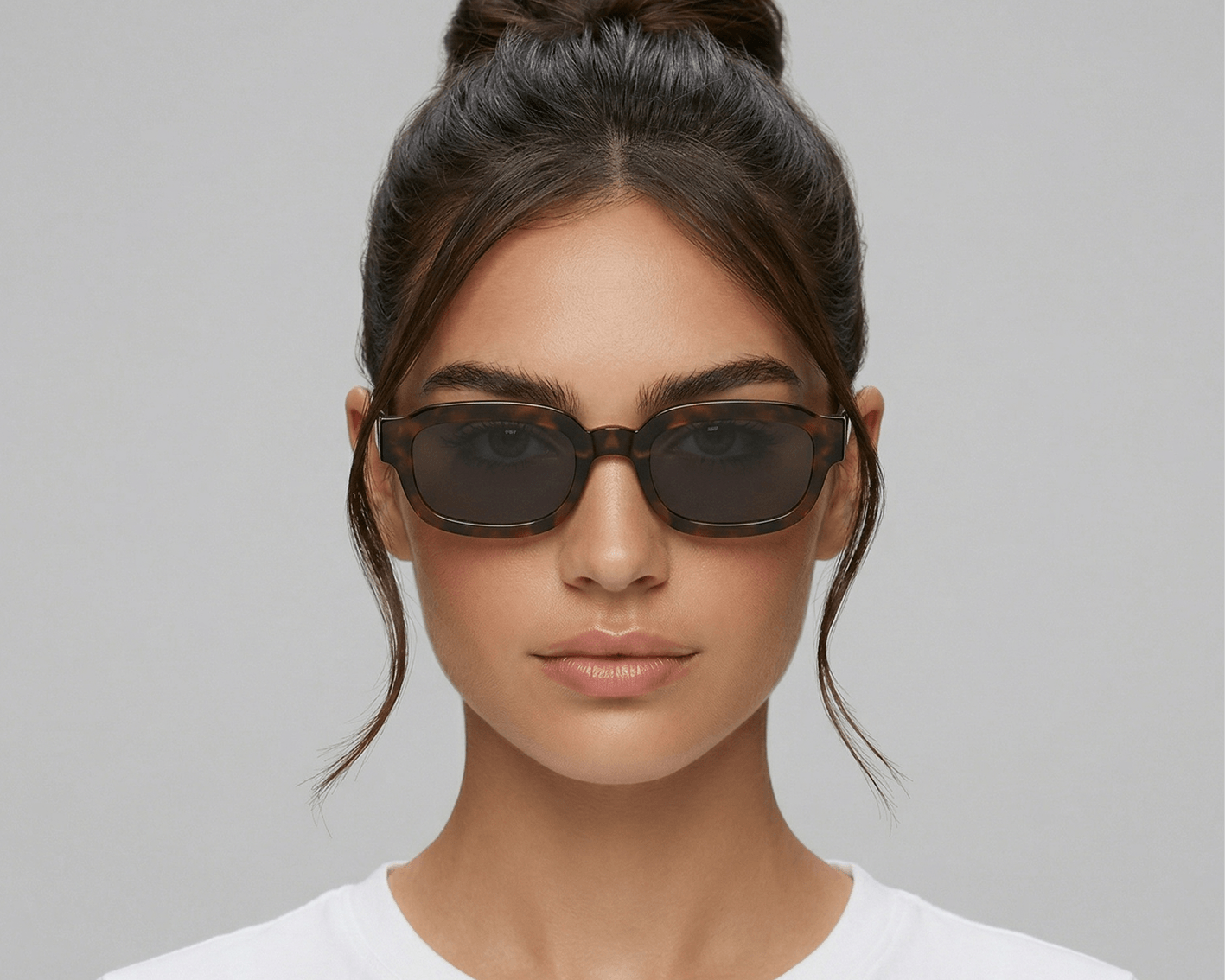 Woman wearing dark sunglasses against a plain background Tortoiseshell