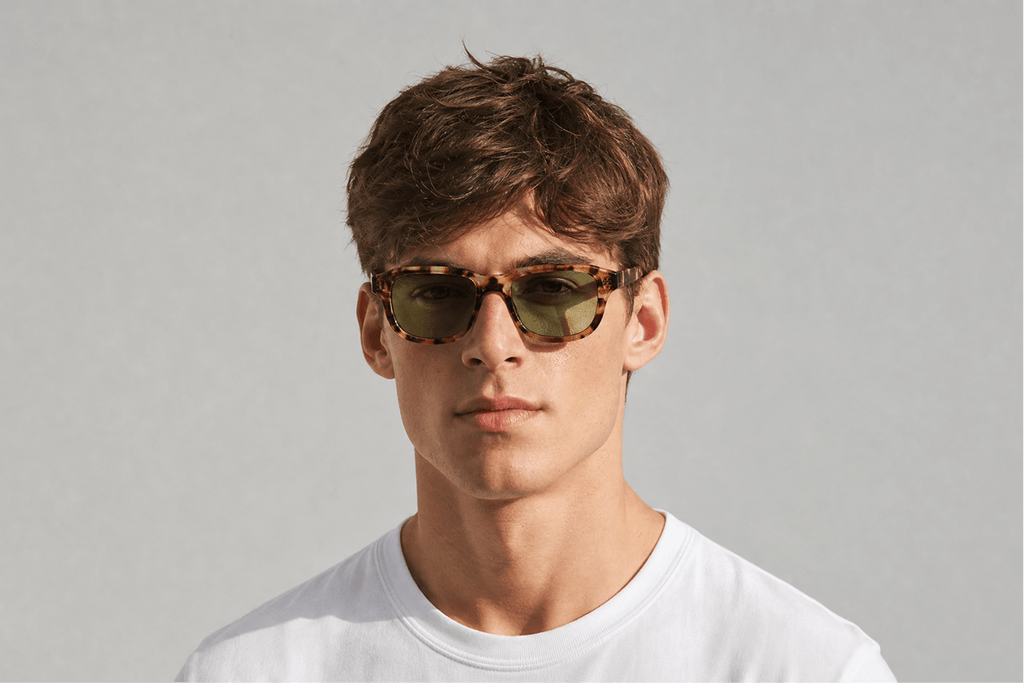 Man wearing sunglasses with a plain gray background Tortoiseshell leo