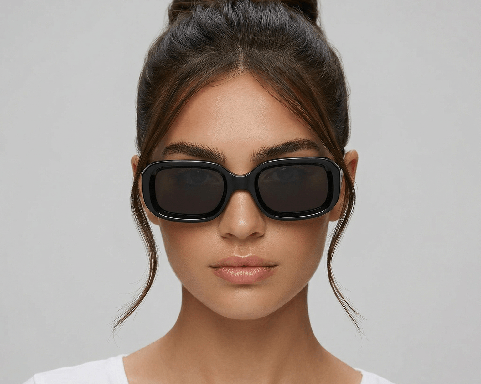 Woman wearing black sunglasses with a plain background Black