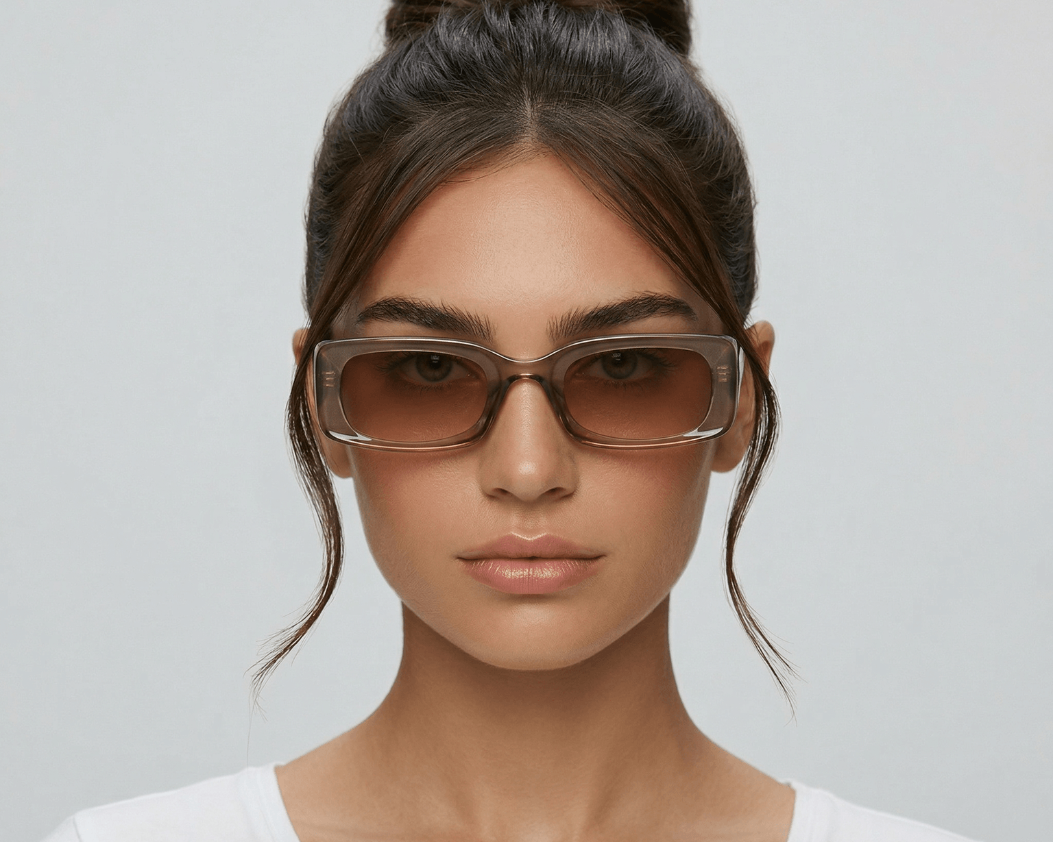 Woman wearing sunglasses with a plain background Clear brown