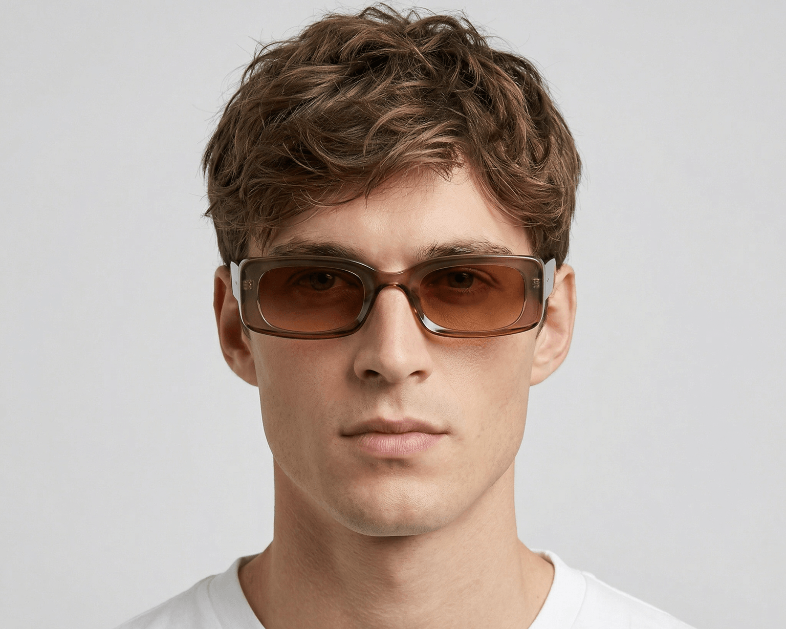 Man wearing brown sunglasses against a light gray background Clear brown