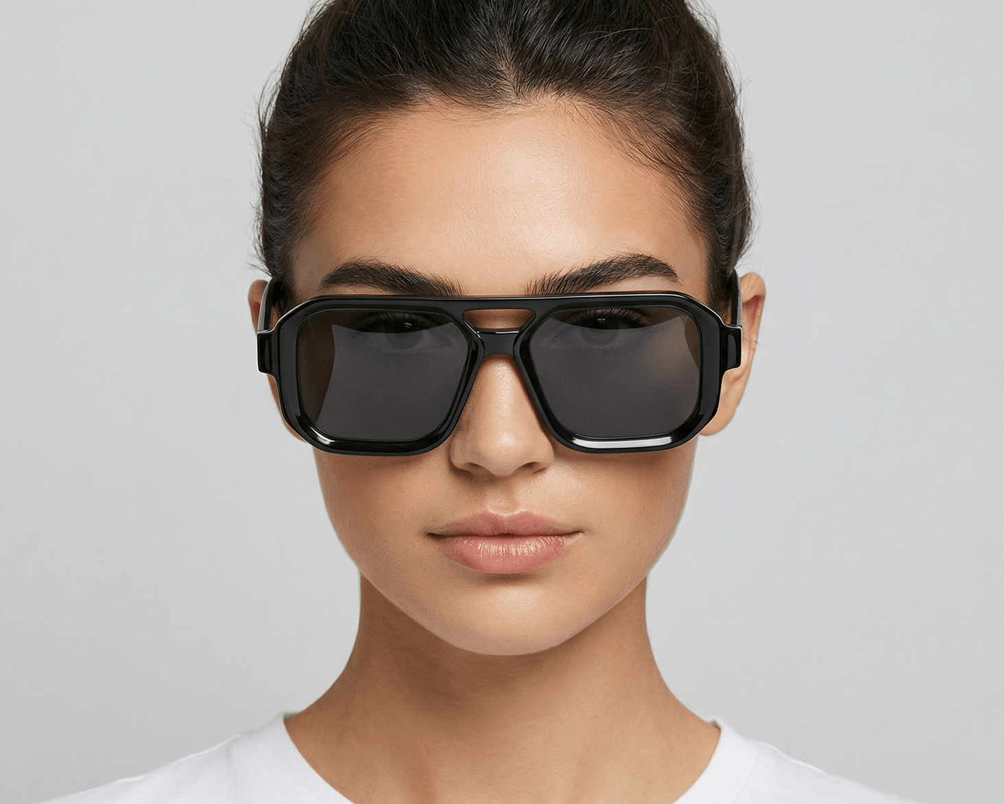 Woman wearing black sunglasses against a plain background Black