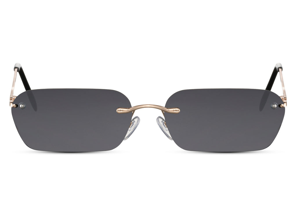 Sunglasses with gold frame and dark lenses on a white background