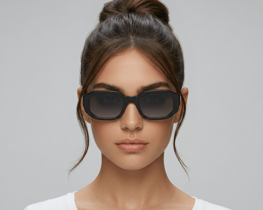 Woman wearing dark sunglasses against a gray background Black
