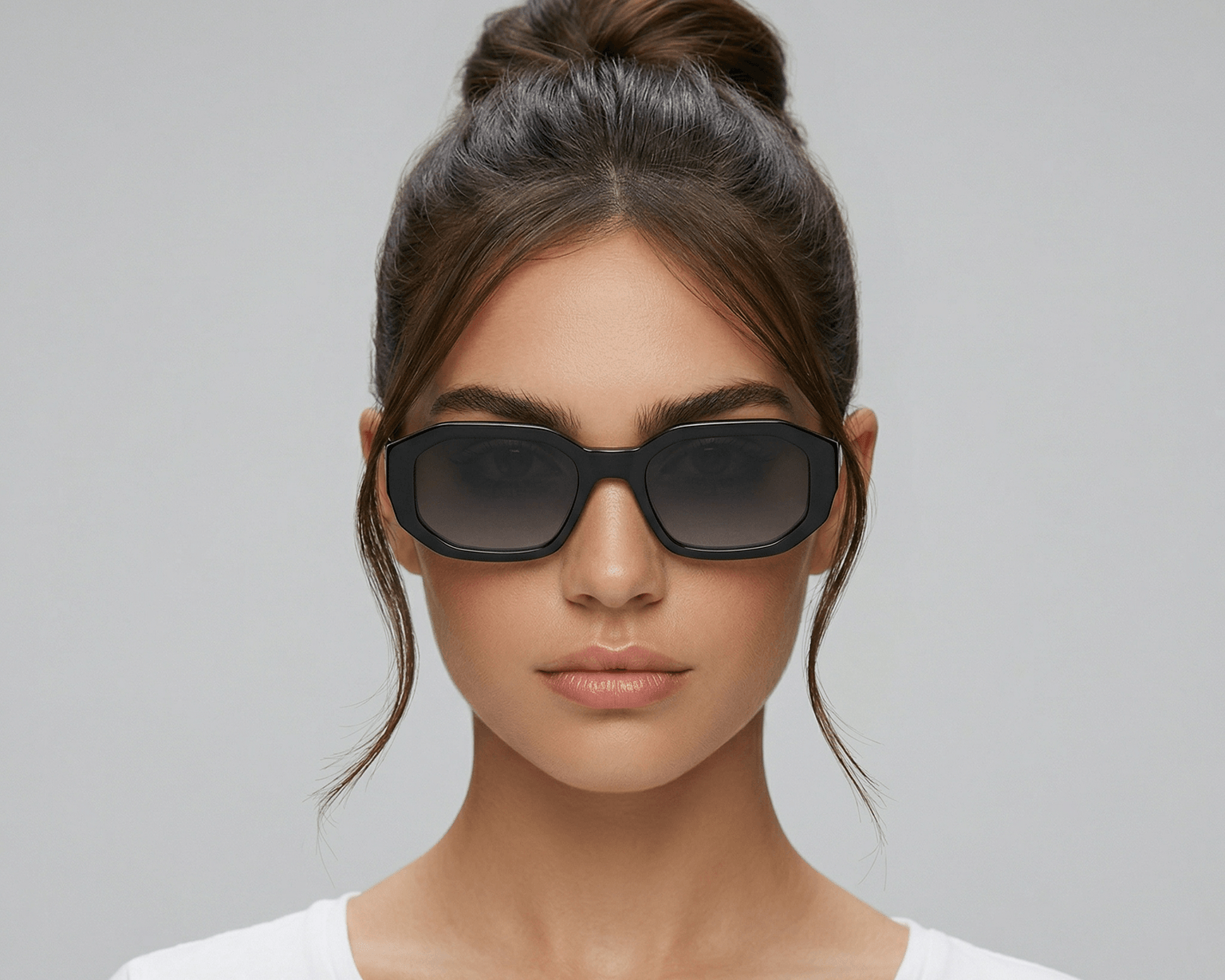 Woman wearing dark sunglasses against a gray background Black