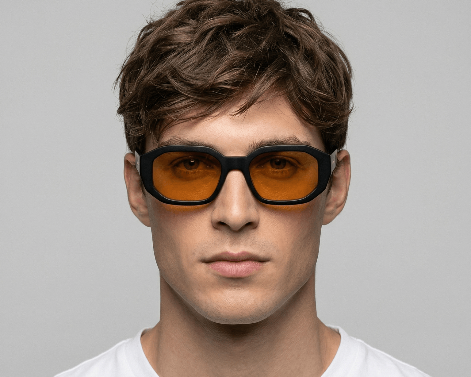 Man wearing Shadow yellow sunglasses with orange lenses against a gray background Shadow yellow