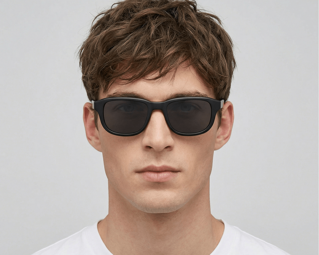 Man wearing dark sunglasses against a plain background