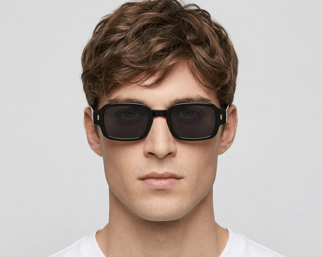 Man wearing black sunglasses against a plain background Black