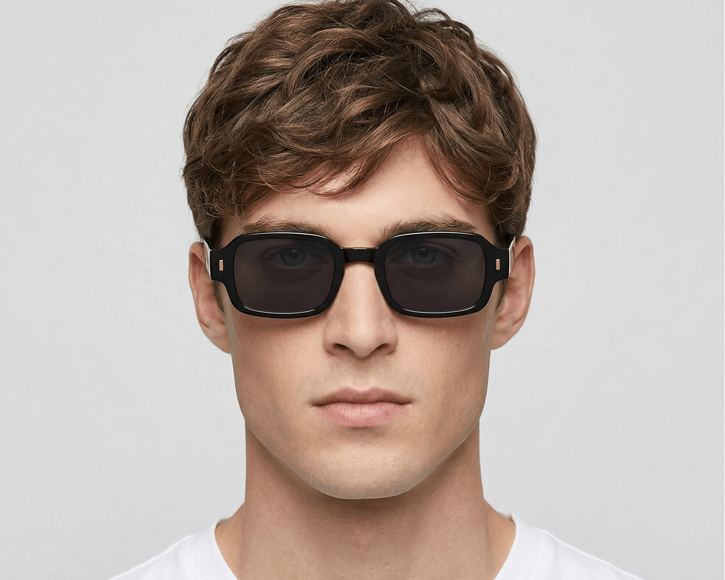 Man wearing black sunglasses against a plain background Black