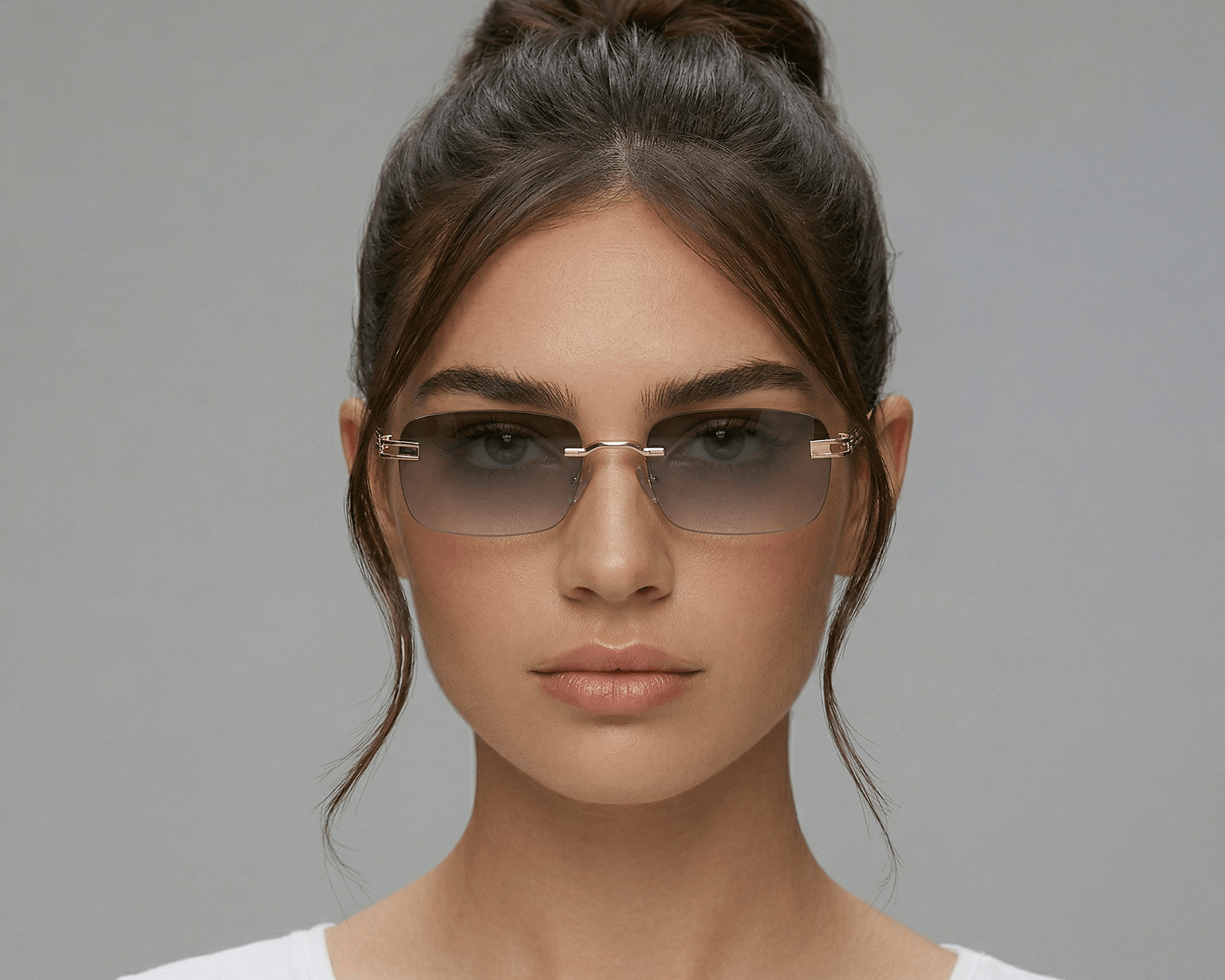 Woman wearing sunglasses with a plain gray background