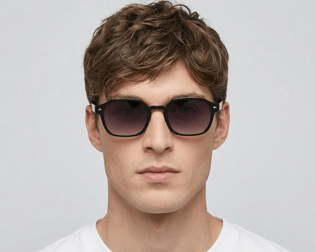 Man wearing dark sunglasses against a plain background