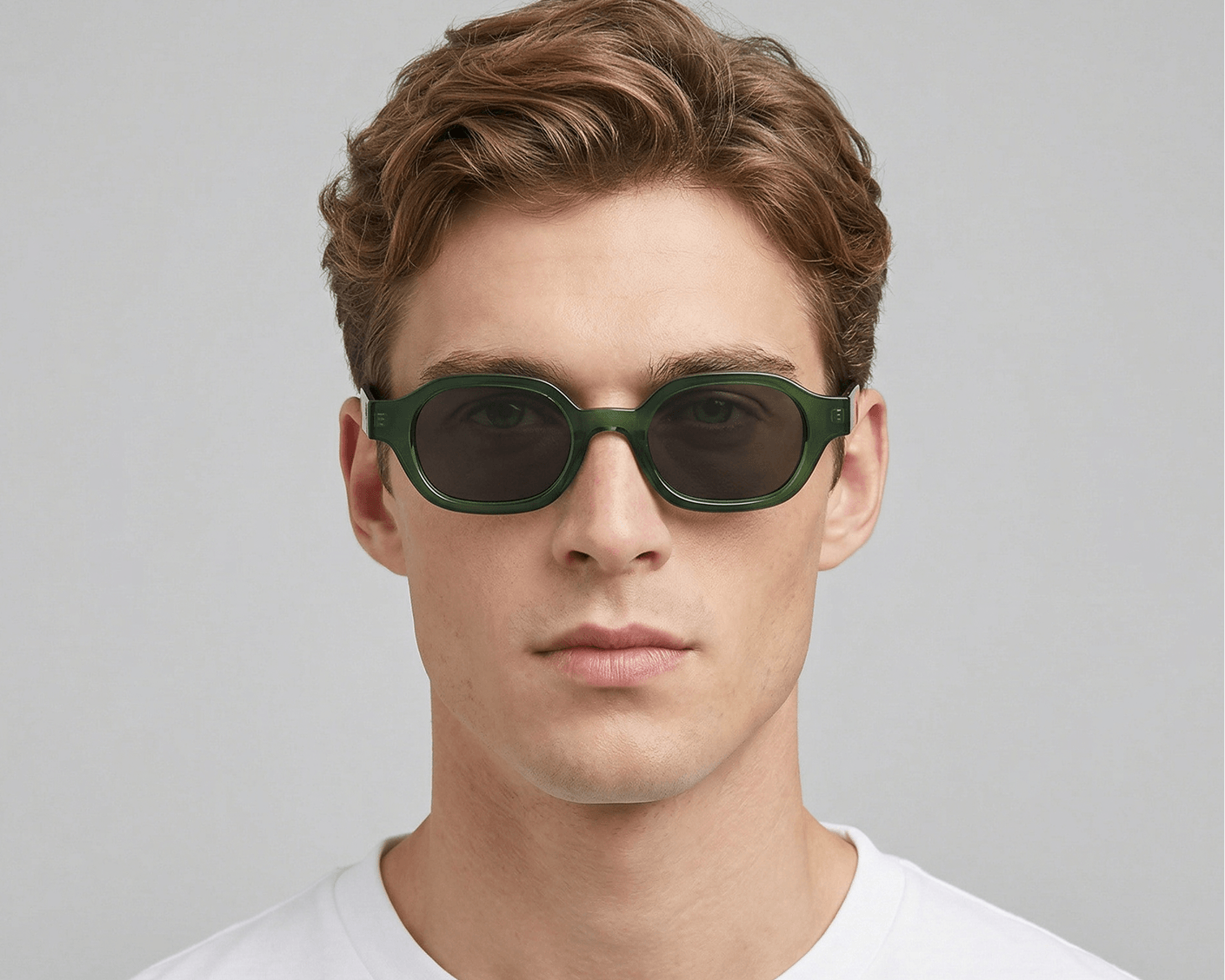 Man wearing green sunglasses against a gray background Clear green