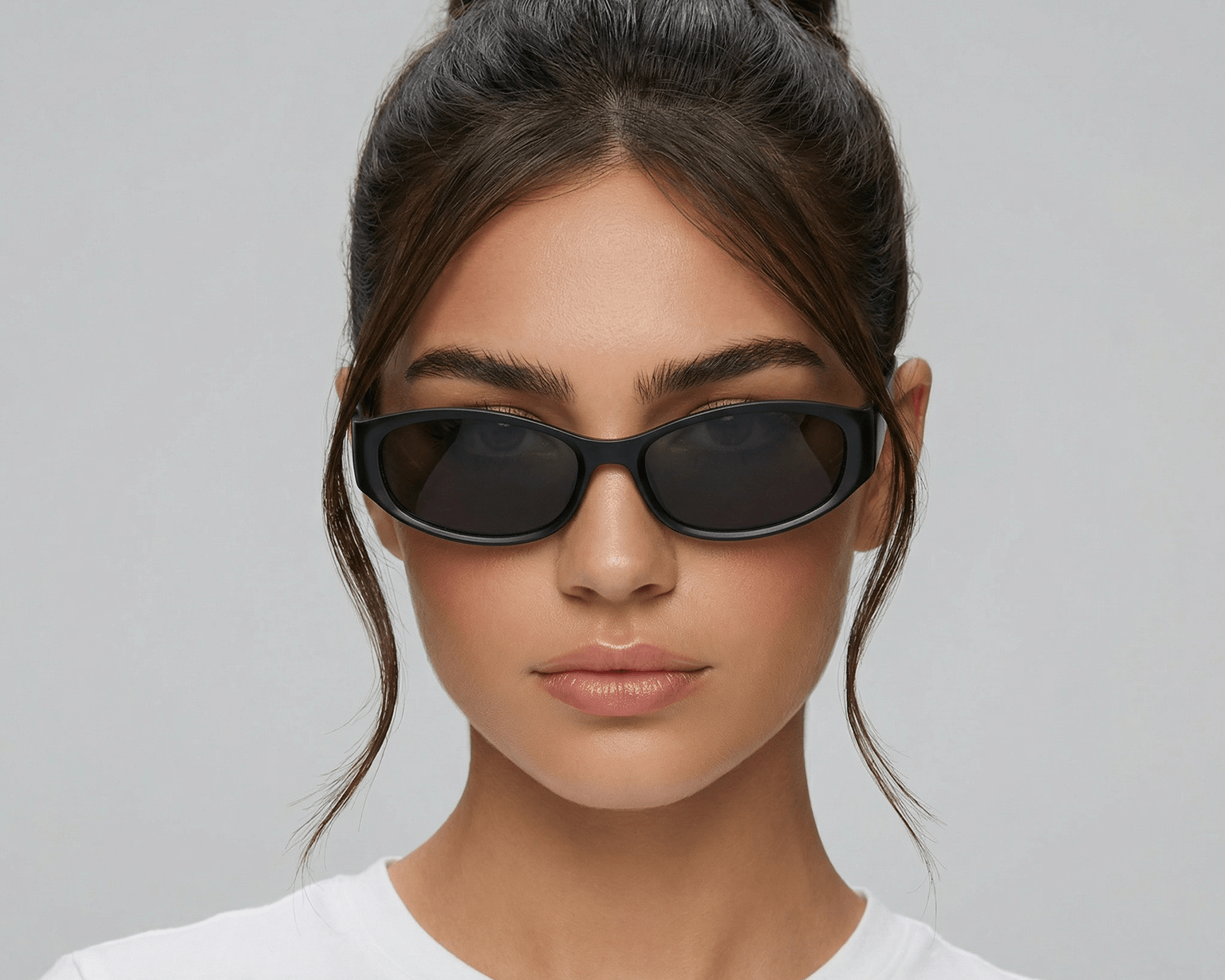 Woman wearing black sunglasses with a plain background