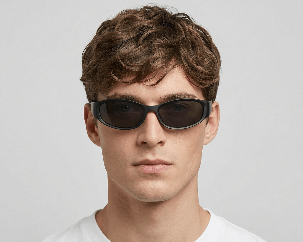 Man wearing dark sunglasses against a plain background
