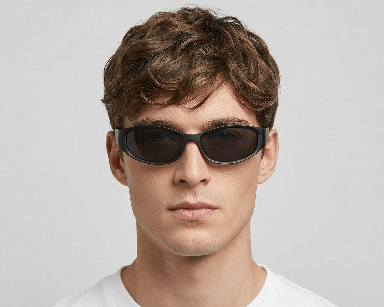 Man wearing dark sunglasses against a plain background